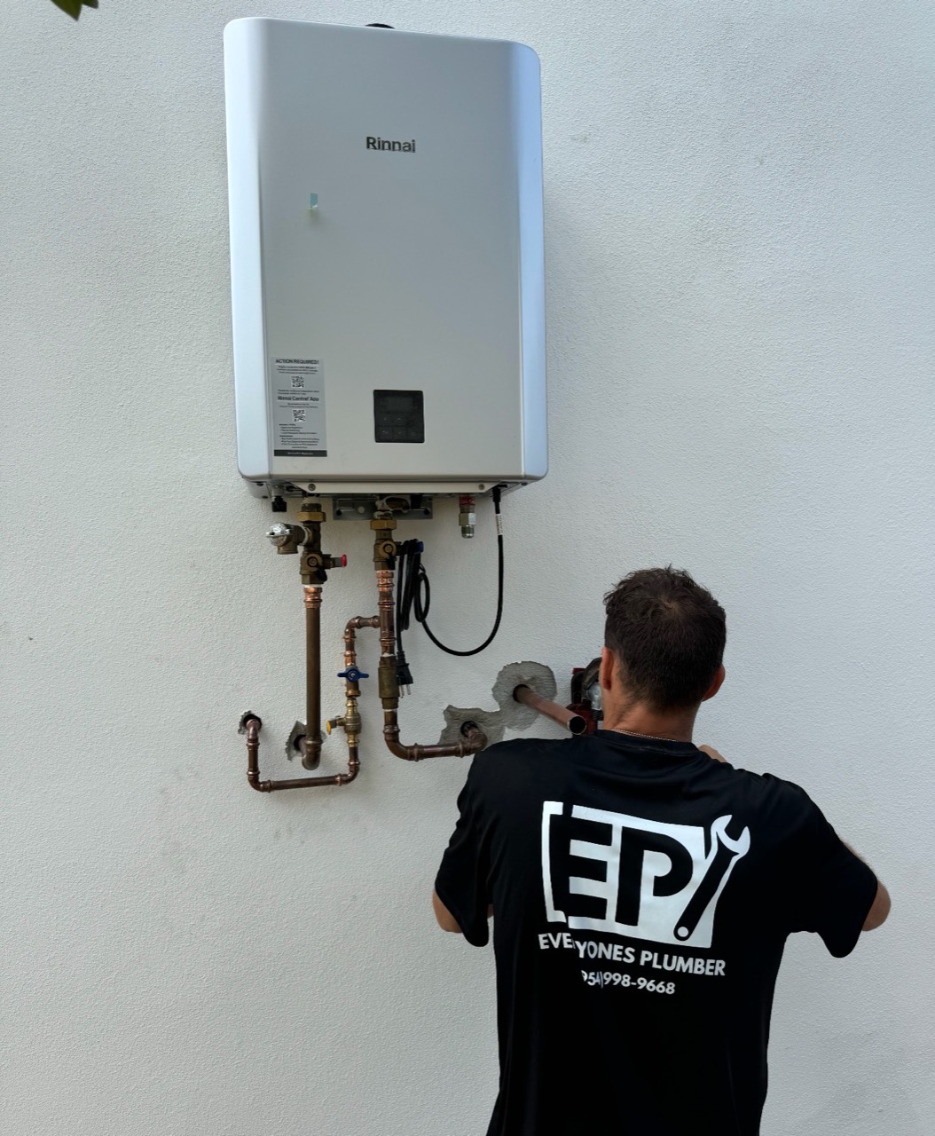 An Everyone's Plumber technician installing the copper connections for a tankless water heater